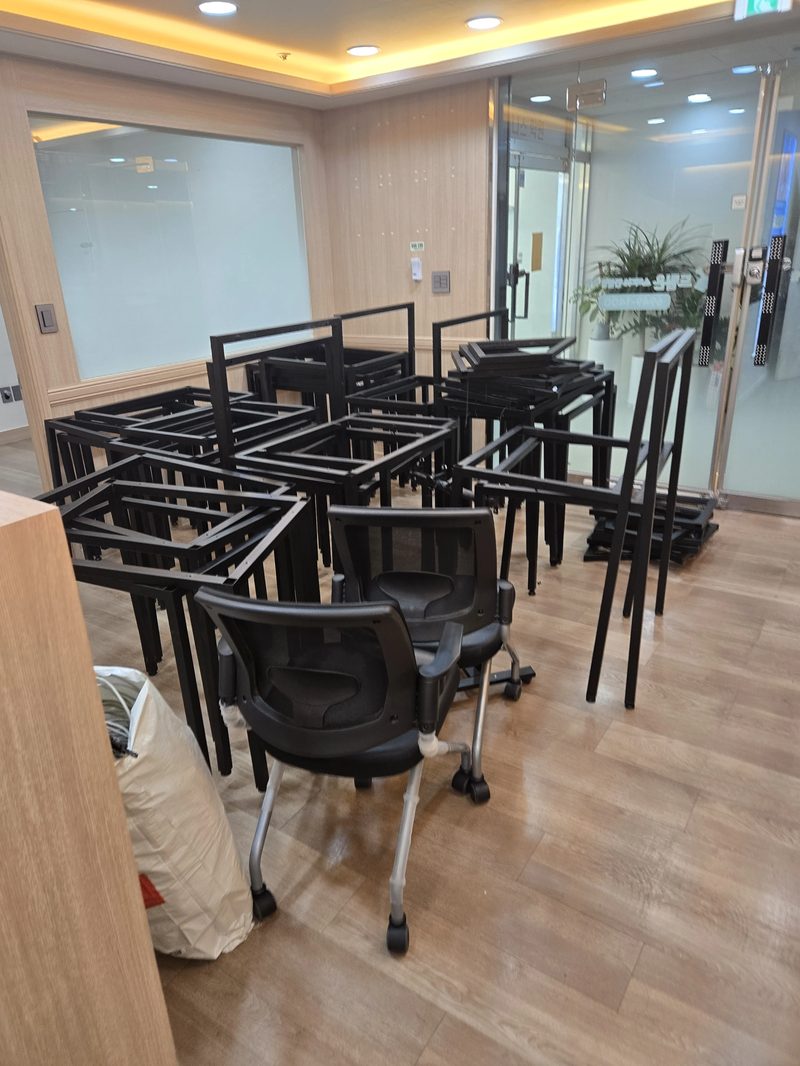 리셉션 구역에서 사무실 데스크 프레임을 해체해 쌓아둔 실제 철거 현장