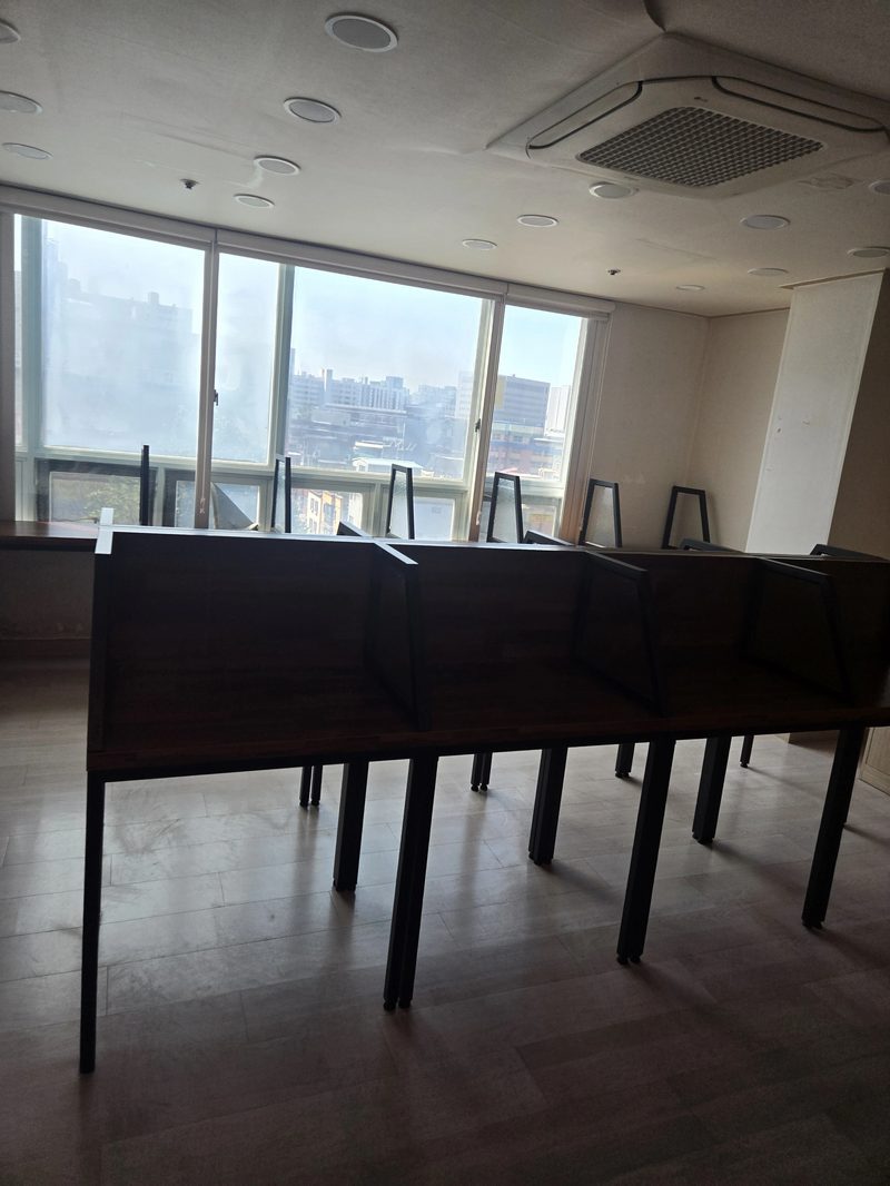 창가에 개인 열람석 칸막이 책상이 줄지어 설치된 독서실 내부, 철거 전 모습